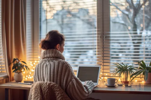 Store thermique blanc installé devant une fenêtre pendant l'hiver pour réduire les pertes de chaleur